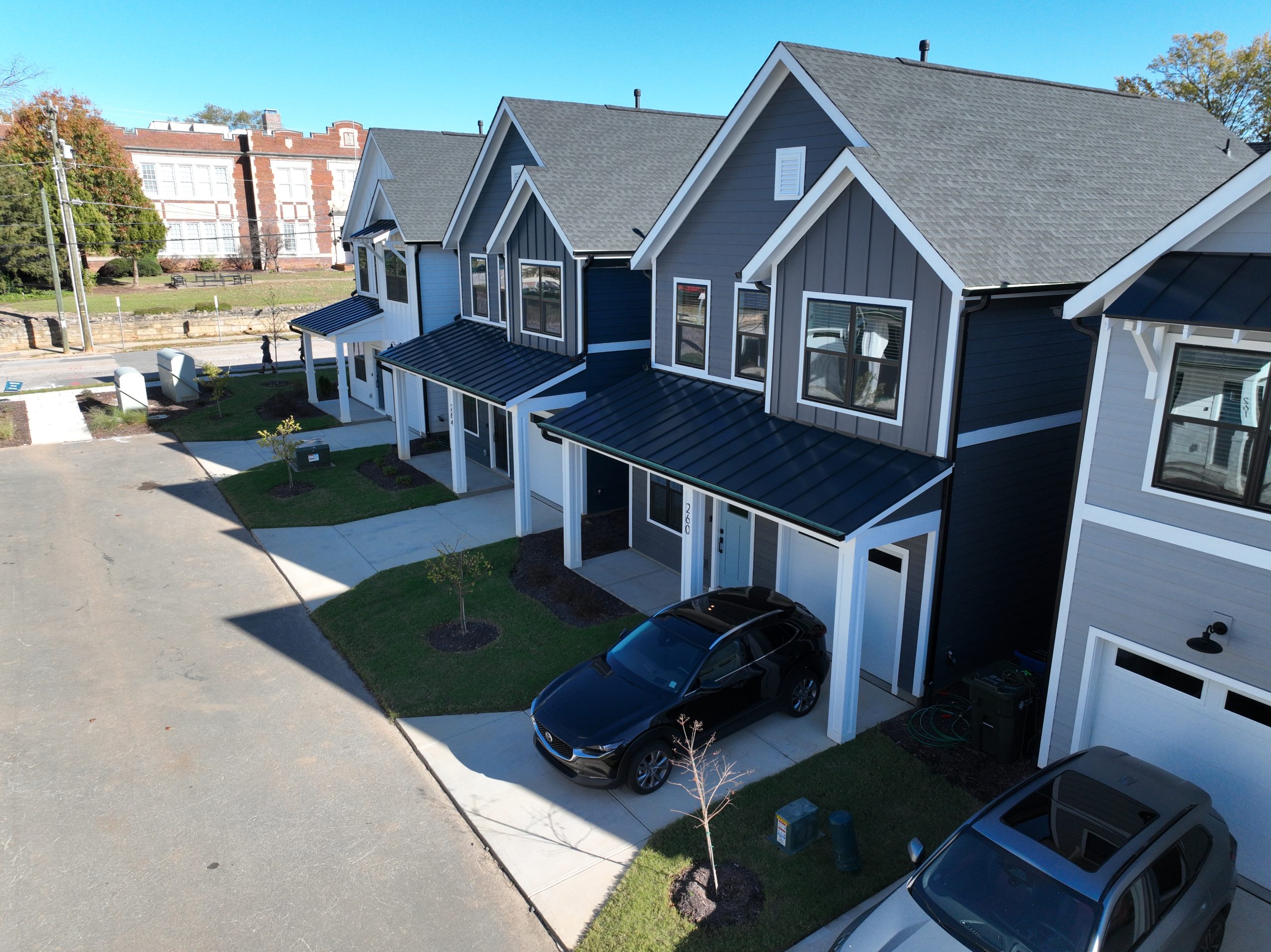 A row of completed build-to-rent homes with cars parked in front of them